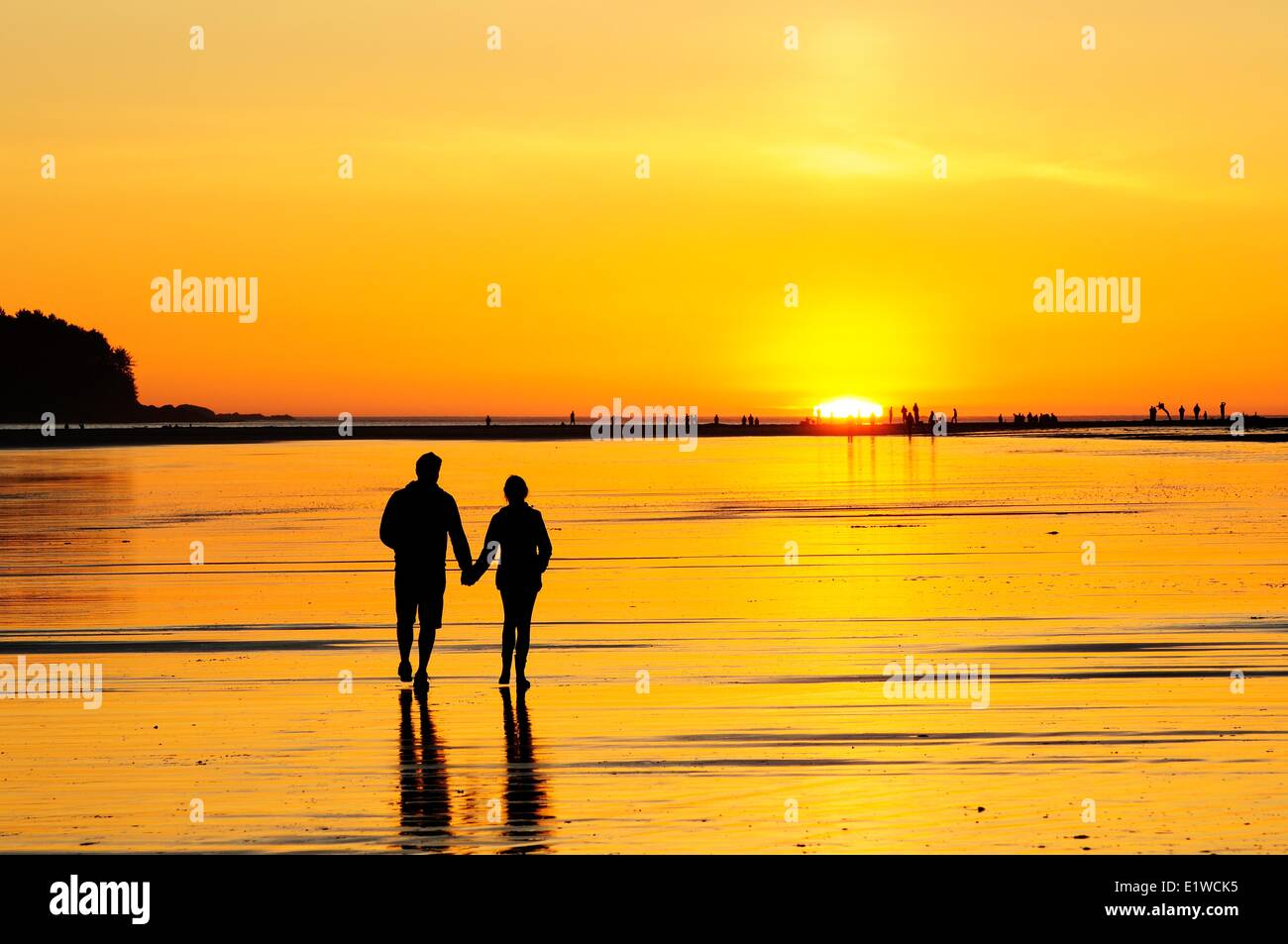 Junges Paar im Sonnenuntergang entlang Chesterman Beach in der Nähe von Tofino, BC. Stockfoto