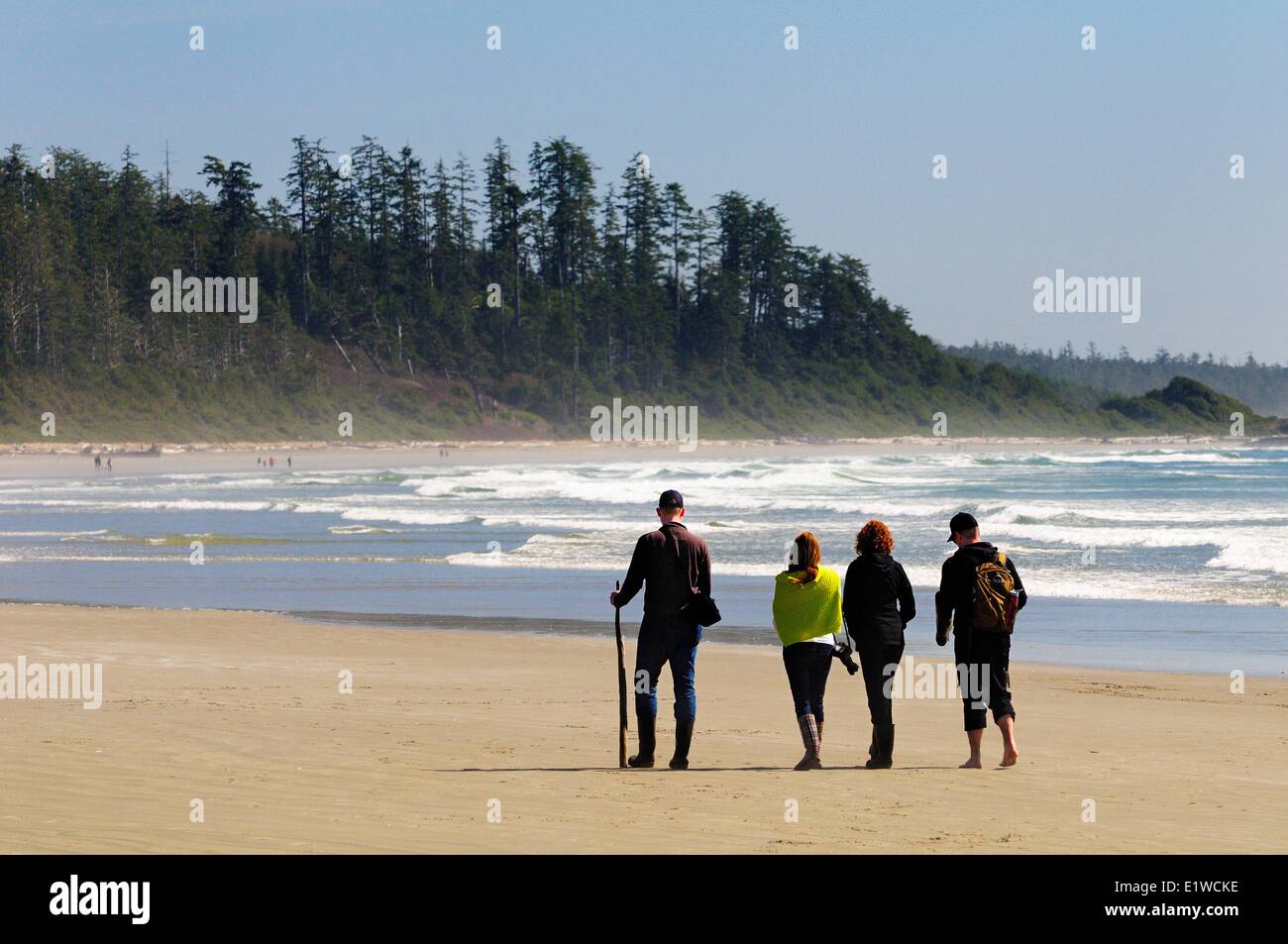Vier Personen zu Fuß entlang der Long Beach im Pacific Rim National Park in der Nähe von Tofino, BC. Stockfoto