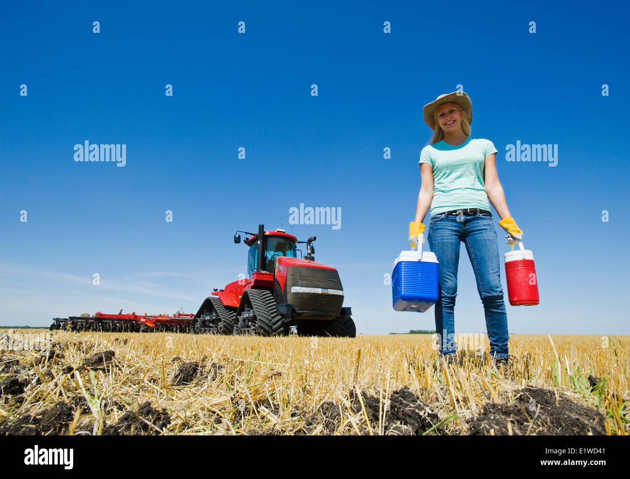 ein Bauernmädchen vor ein Traktor mit einem Disker, in der Nähe von Dugald, Manitoba, Kanada Stockfoto