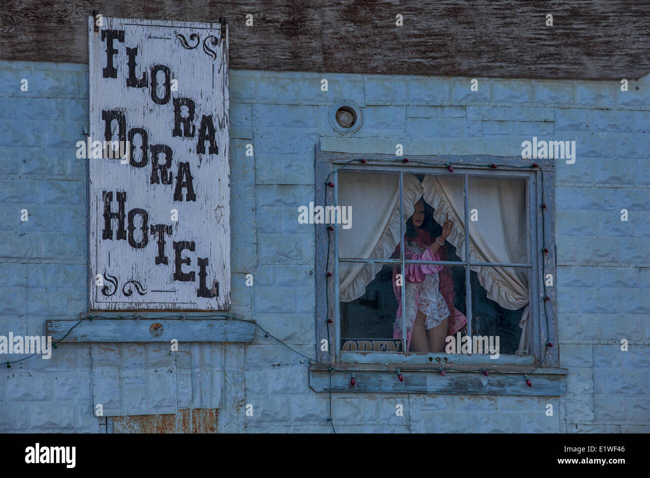Ein Mannequin starrt aus dem Fenster des verlassenen Flora Dora Hotel in Dawson City, Yukon. Stockfoto