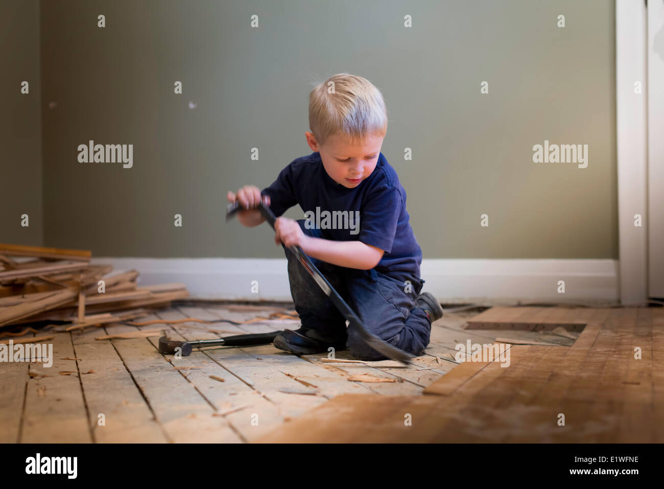 Kleiner Junge Tischler mit einem Hammer und Hartholz Boden zu spielen. Stockfoto