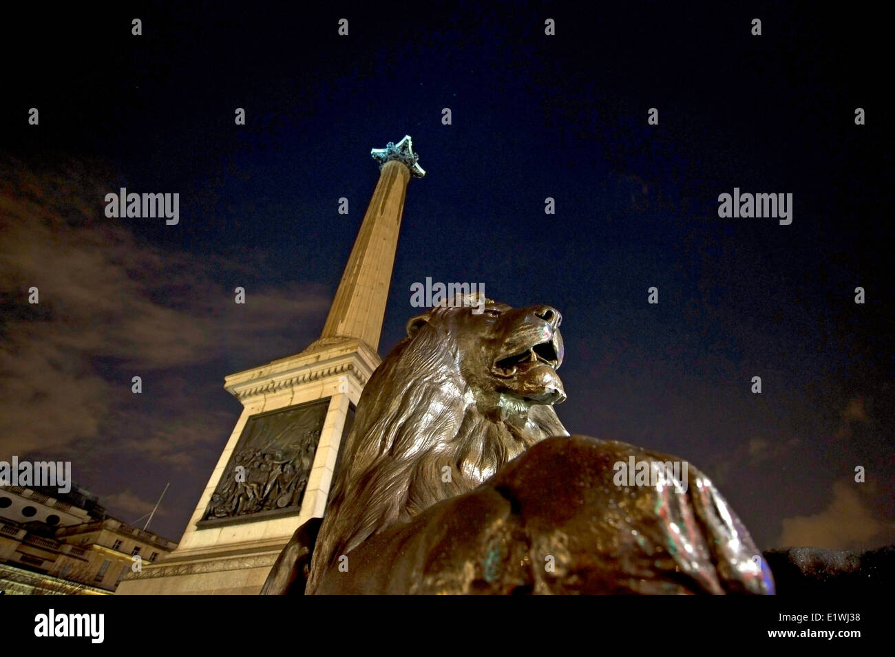 Löwe aus Bronze und Nelson-Säule auf dem Trafalgar Square in der Nacht Stockfoto