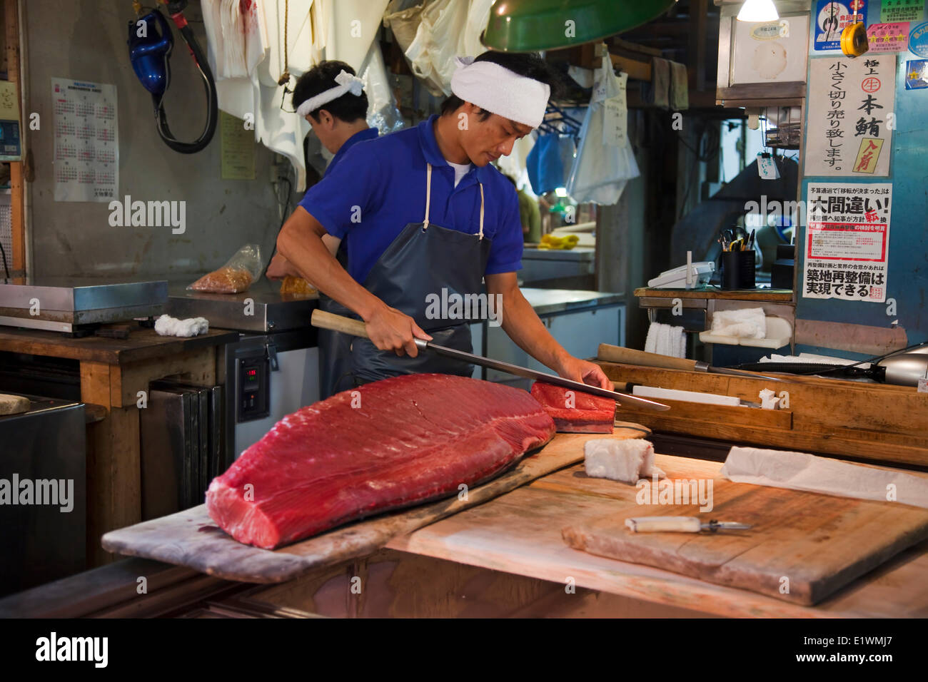 Fischverkäufer sorgfältig Stücke von Thunfisch mit einem langen Messer schnitzen rief Oroshi-Hocho am Tsukiji-Markt. Eine wichtige touristische Attraktion Stockfoto