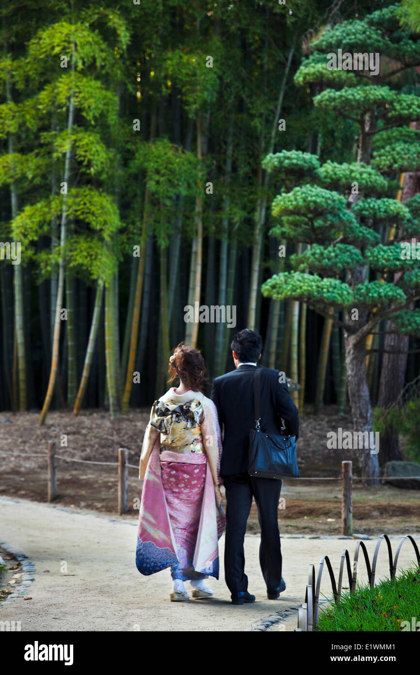 Paar in der Nähe eines Bambushains in Okayama Korakuen Garten schlendern. Die Frau trägt einen Furisode-Kimono, was übersetzt " Stockfoto