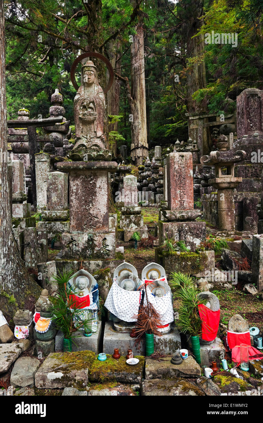 Gruppieren von Grabsteinen kleine Statuetten Marterrad mit roten oder weißen Lätzchen, die Jizo Bodhisattvas darstellen, die nach Stockfoto