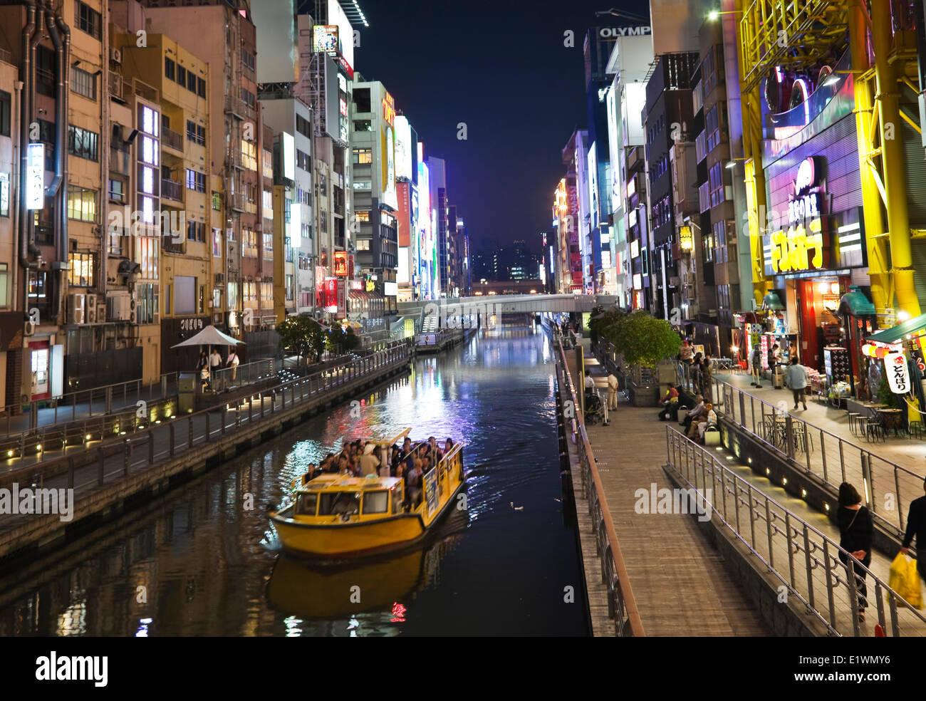 Tourenboot Kreuzfahrt entlang des berühmten Dotombori Kanals in Osaka, Japan, sind zahlreiche Restaurants und Cafés sowie eine 4-geschossige di Stockfoto
