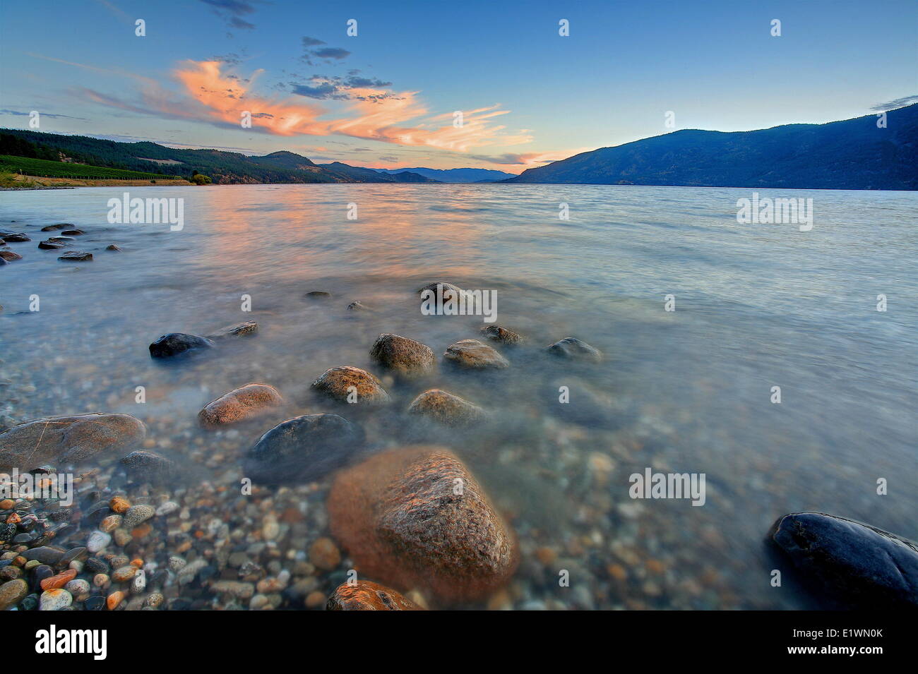 eine Ansicht des Okanagan Lake bei Sonnenuntergang mit Felsen im Vordergrund, Darrel Giesbrecht Stockfoto