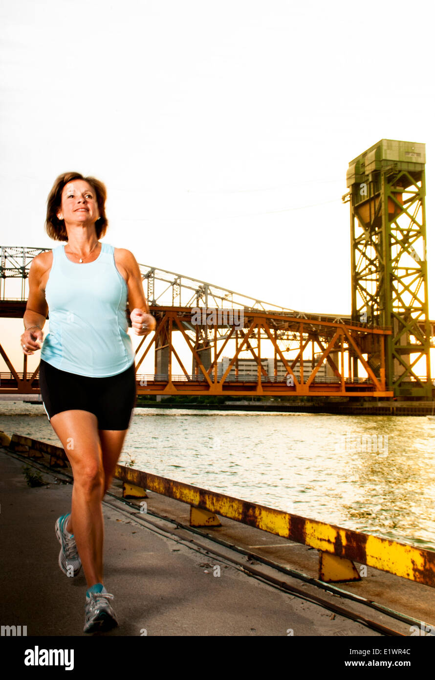 Attraktive Frau in ihrem 50 ist auf einen urban Trail Joggen. Stockfoto