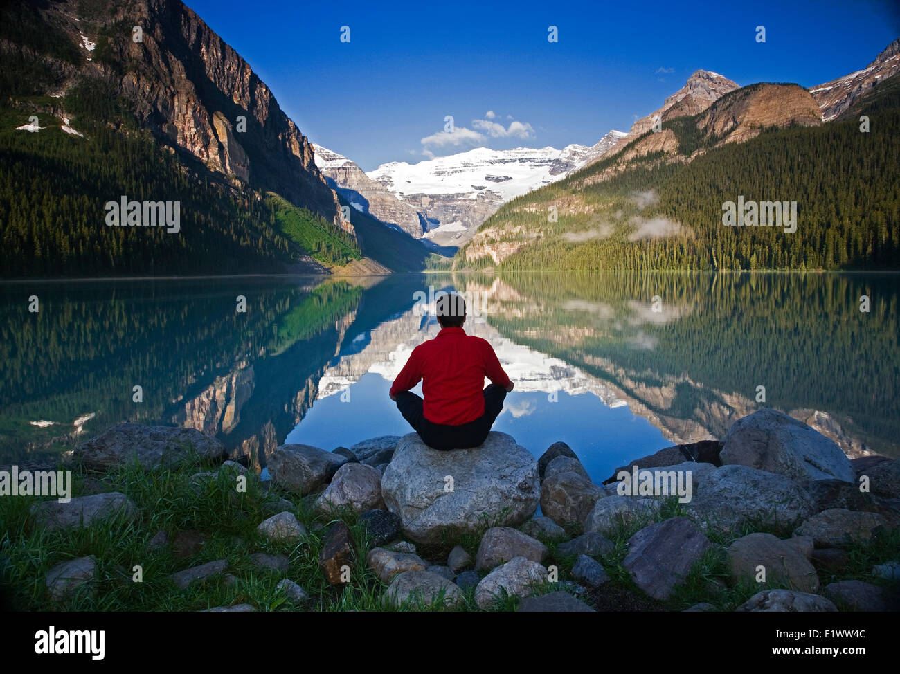 Mittleren Alters, Männlich meditieren auf Felsen am Lake Louise, Alberta, Kanada. Stockfoto