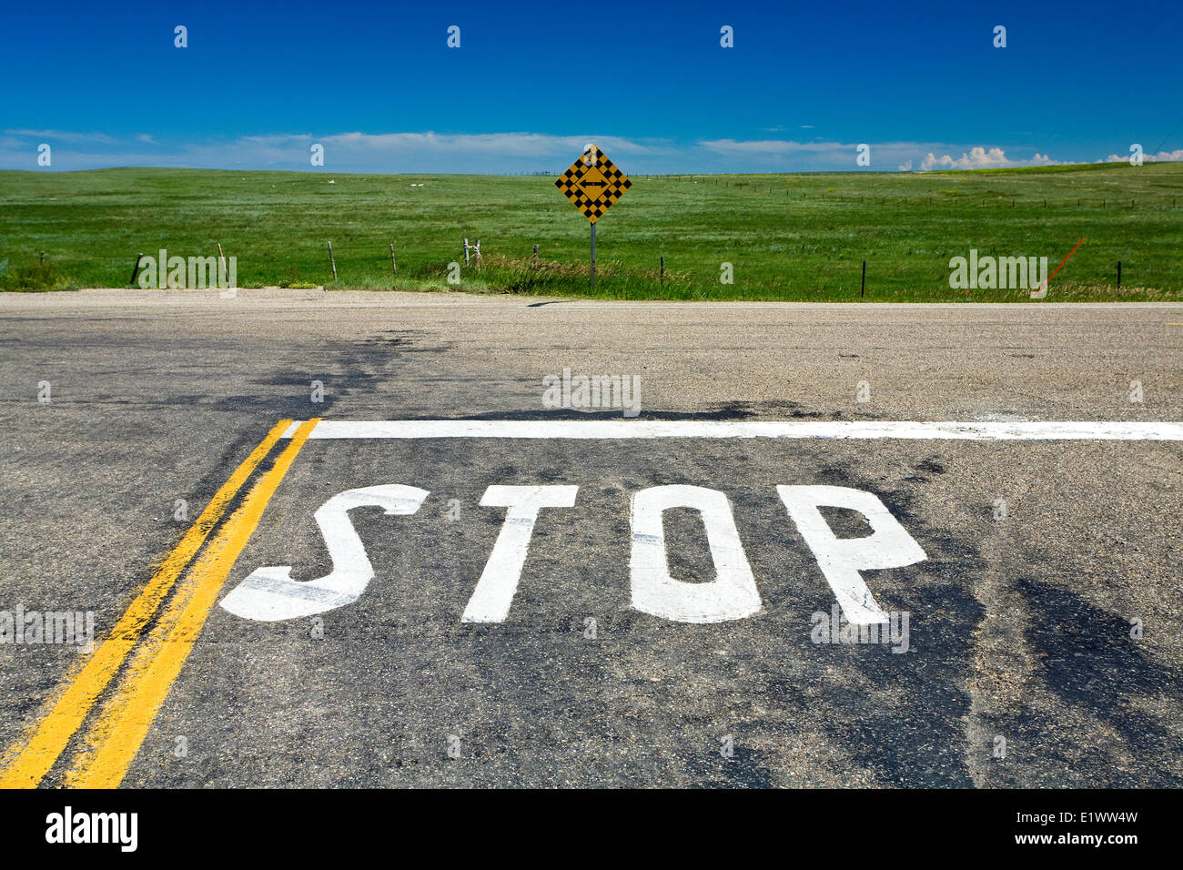 Stop-Schild gemalt auf Landstraße mit Richtung Zeichen, Süd-Alberta, Kanada. Stockfoto