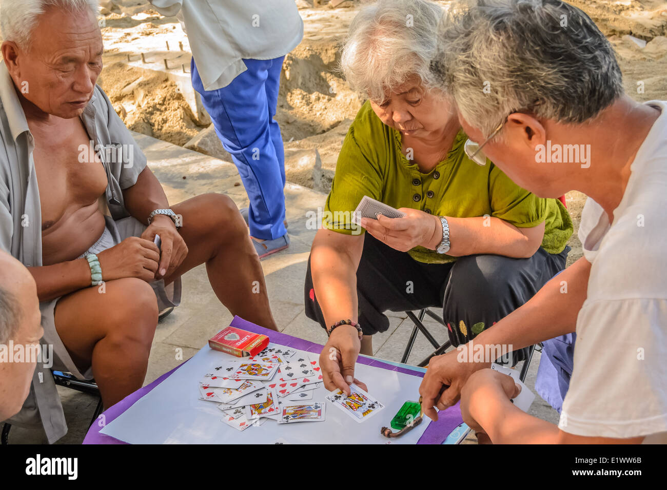 Einige alte Leute spielen Poker am Sommerstrand. Stockfoto