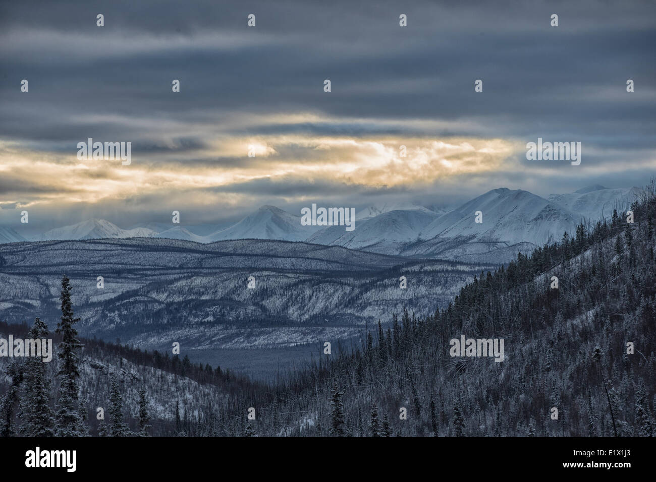 Licht kommt durch die Wolken über das St. Cyr-Gebirge in der Nähe von Faro, in zentralen Yukon. Stockfoto