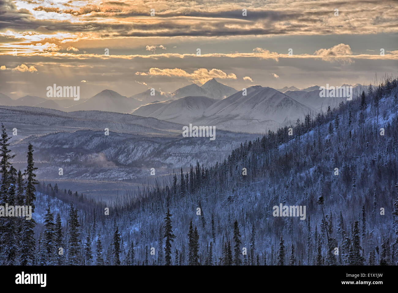 Licht kommt durch die Wolken über das St. Cyr-Gebirge in der Nähe von Faro, in zentralen Yukon. Stockfoto