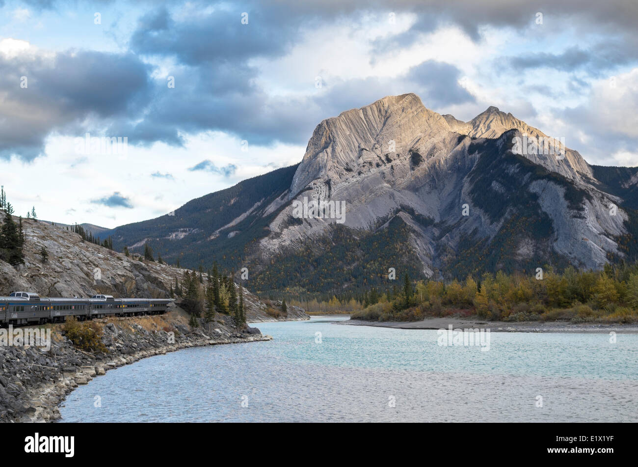 Personenzug entlang des Athabasca River und Roche Miette bei Sonnenuntergang in den Rocky Mountains, Alberta, Kanada. Stockfoto