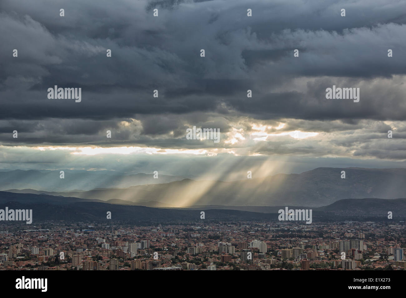 Wellen von Licht Shne unten durch Gewitterwolken über Oberseite von Cochabamba, Bolivien. Stockfoto