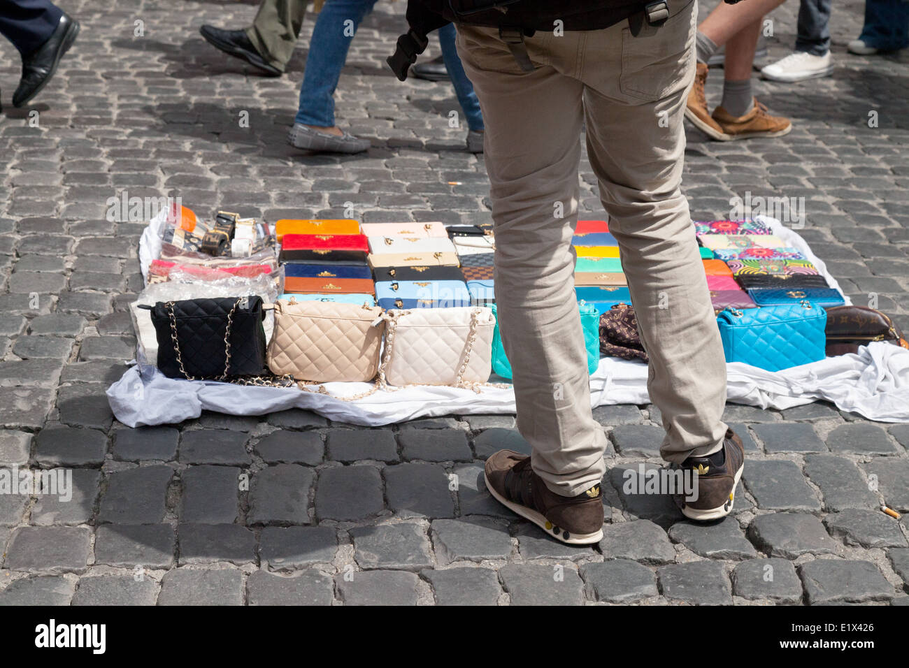 Straßenhändler verkaufen Handtaschen auf den gepflasterten Strassen von Rom, Italien Europa Stockfoto