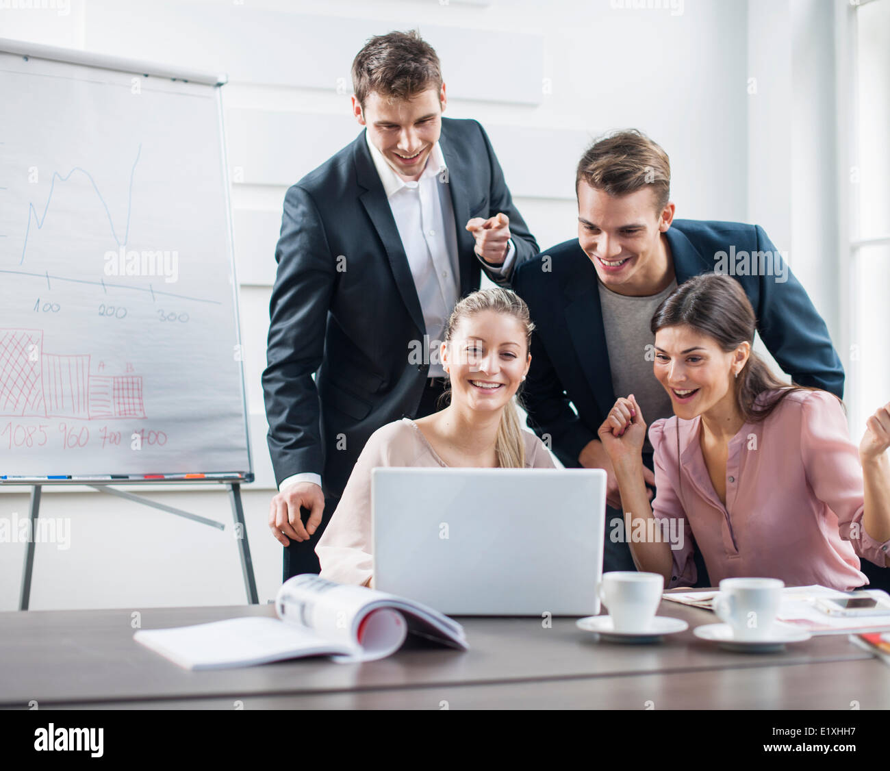 Erfolgreiche junge Geschäftsleute mit Laptop in treffen Stockfoto