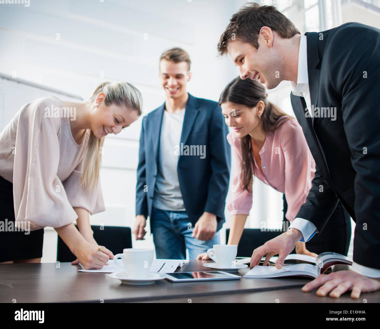 Glückliche junge Geschäftsleute brainstorming am Konferenztisch Stockfoto