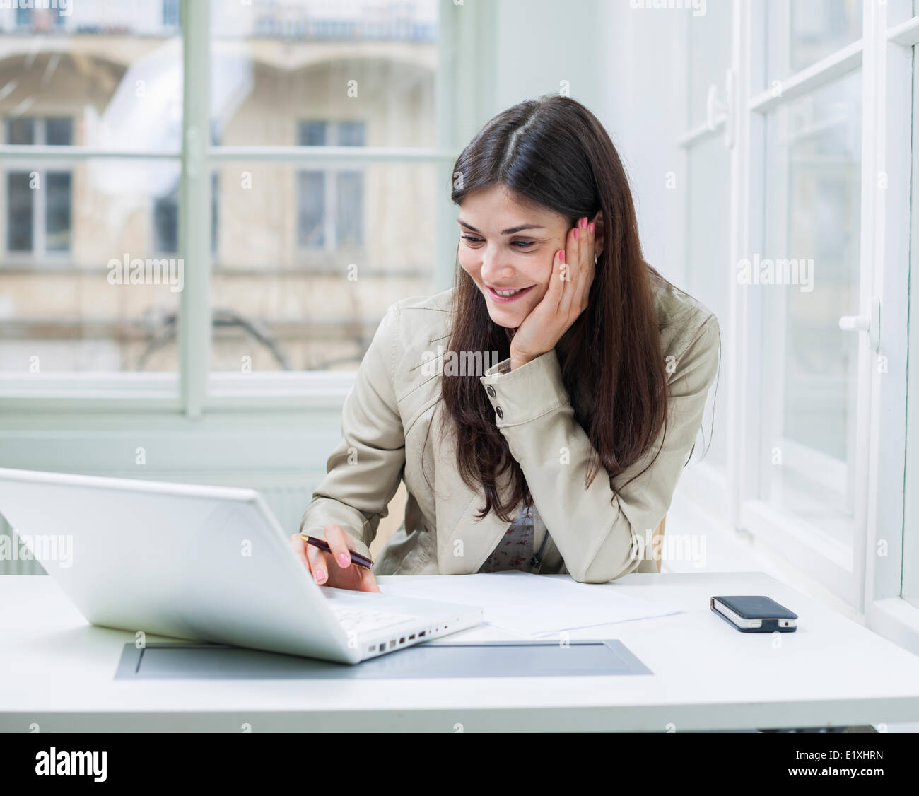 Junge Geschäftsfrau mit Laptop am Schreibtisch Stockfoto