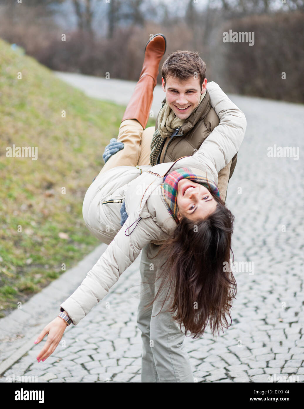 Porträt der glückliche Mann trägt Frau im park Stockfoto