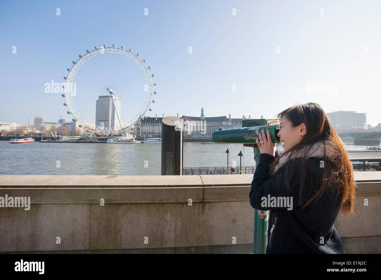 Junge Frau, die am London Eye über stationäre Viewer in London, England, UK Stockfoto