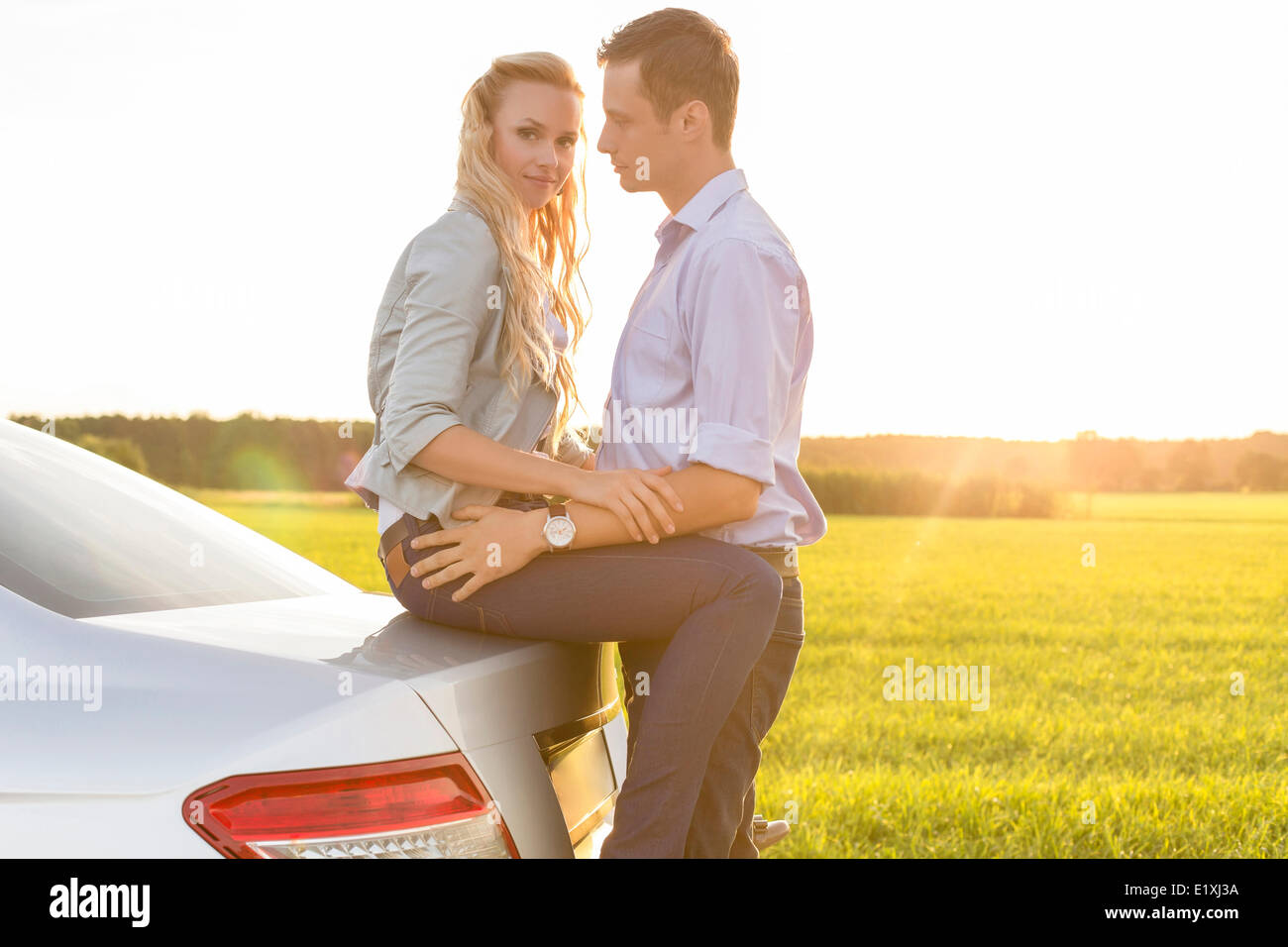 Seitenansicht des romantischen junges Paar mit dem Auto auf Land Stockfoto
