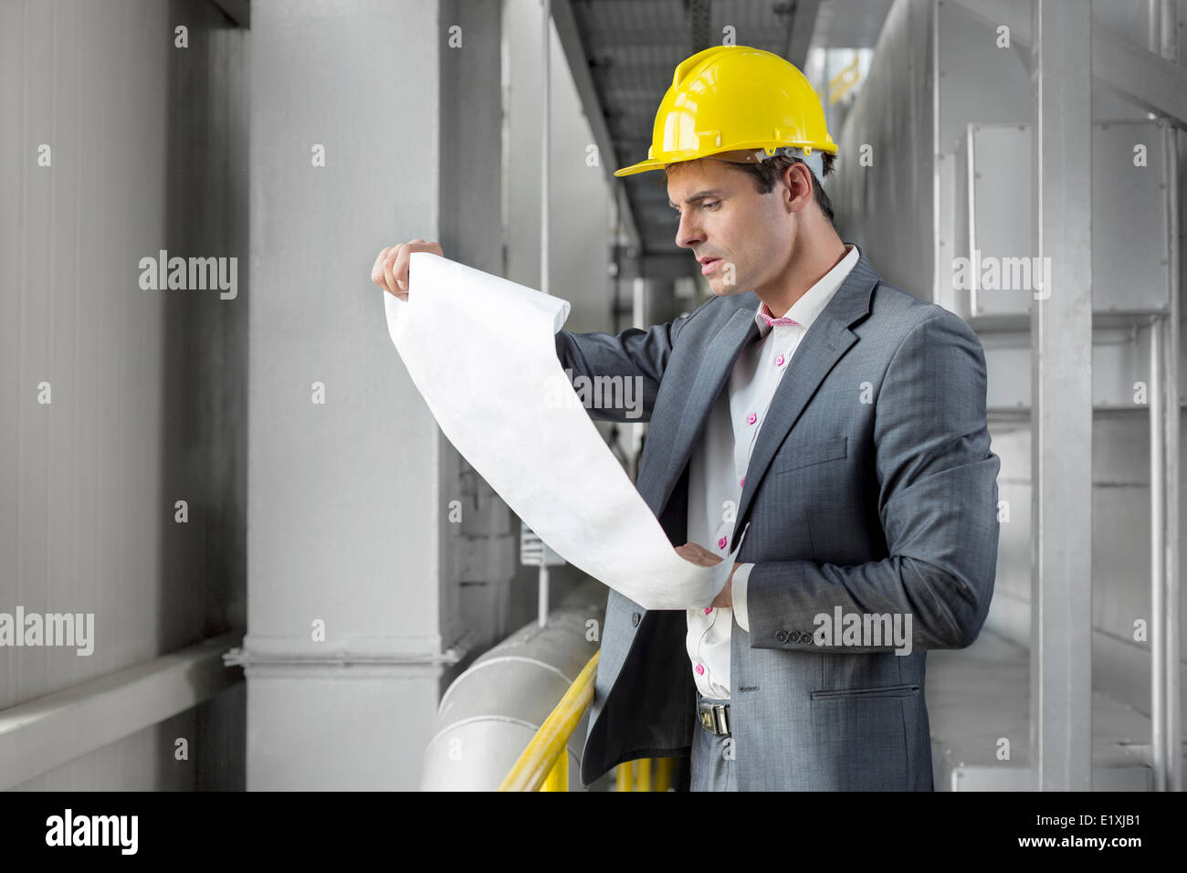 Junge männliche Architekt Prüfung Blaupause in der Industrie Stockfoto