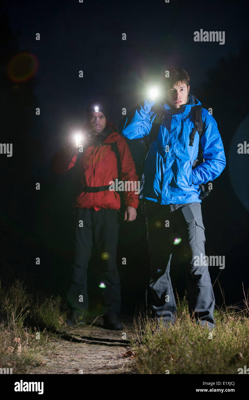 In voller Länge Portrait von männlichen Rucksacktouristen mit Taschenlampen im Feld in der Nacht Stockfoto