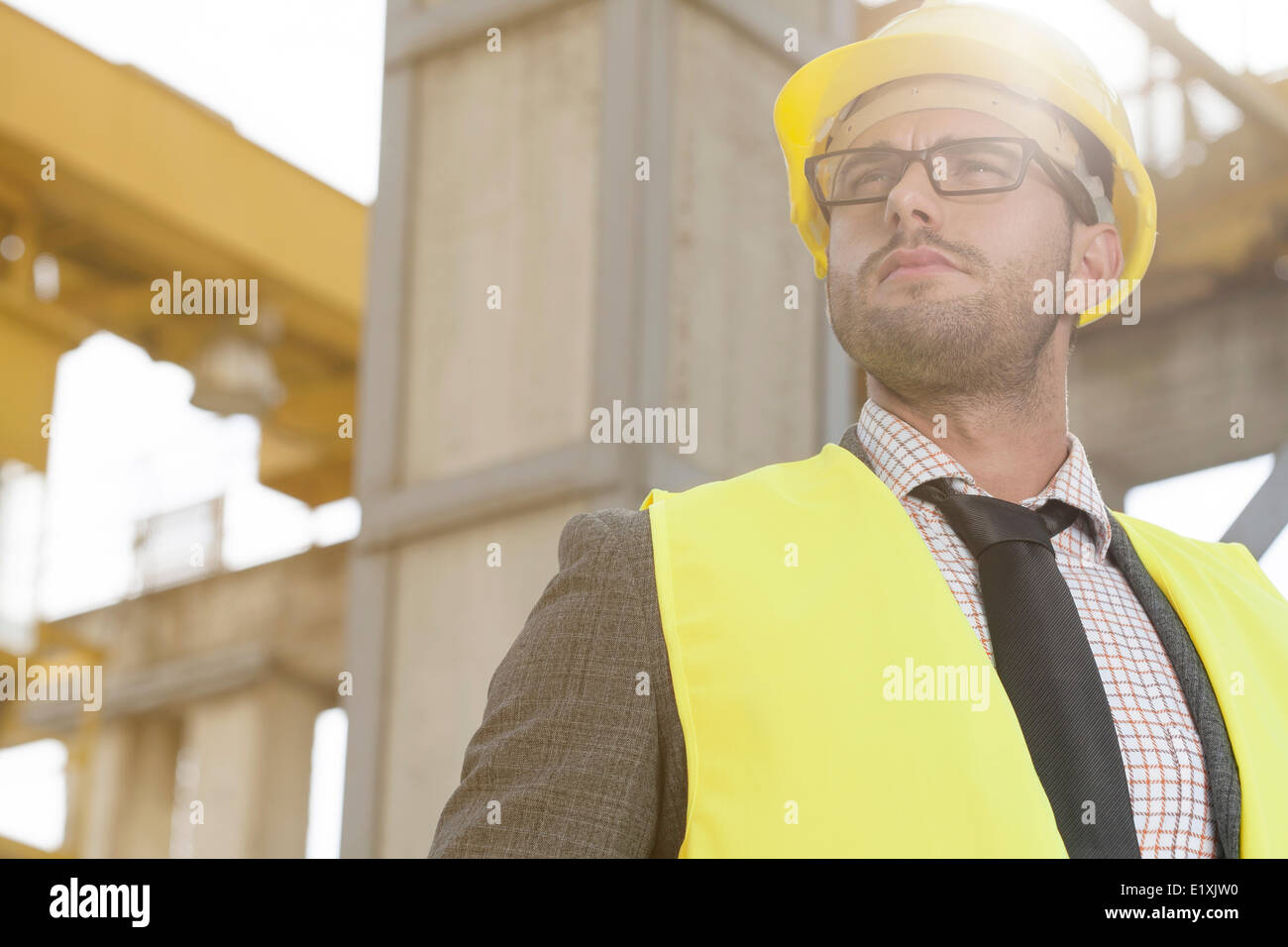 Nachdenklichen jungen männlichen Architekten in Schutzkleidung auf Baustelle Stockfoto