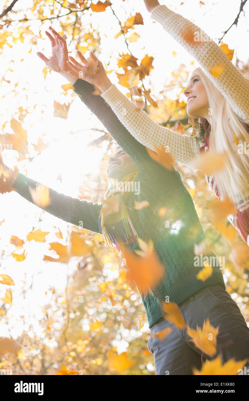 Paar mit Armen angehoben genießen fallende Blätter im Herbst im park Stockfoto