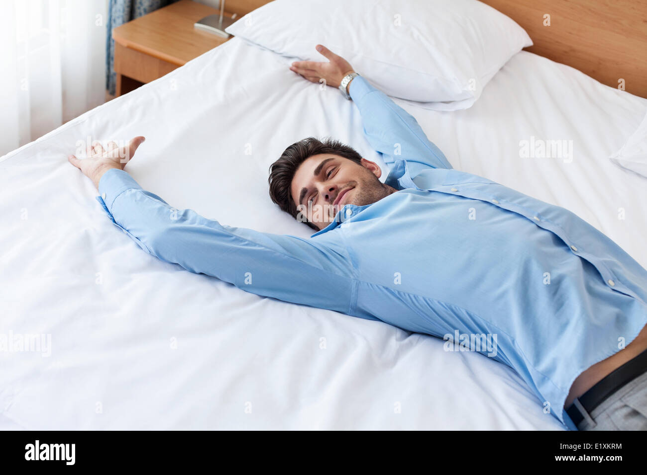 Erschöpften jungen Geschäftsmann im Bett liegend Stockfoto