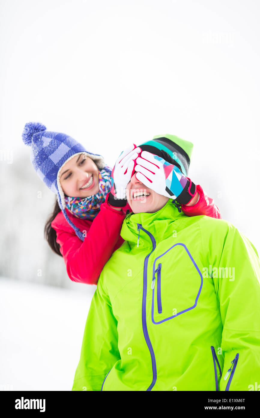 Lächelnde junge Frau mit den Augen des Mannes im winter Stockfoto