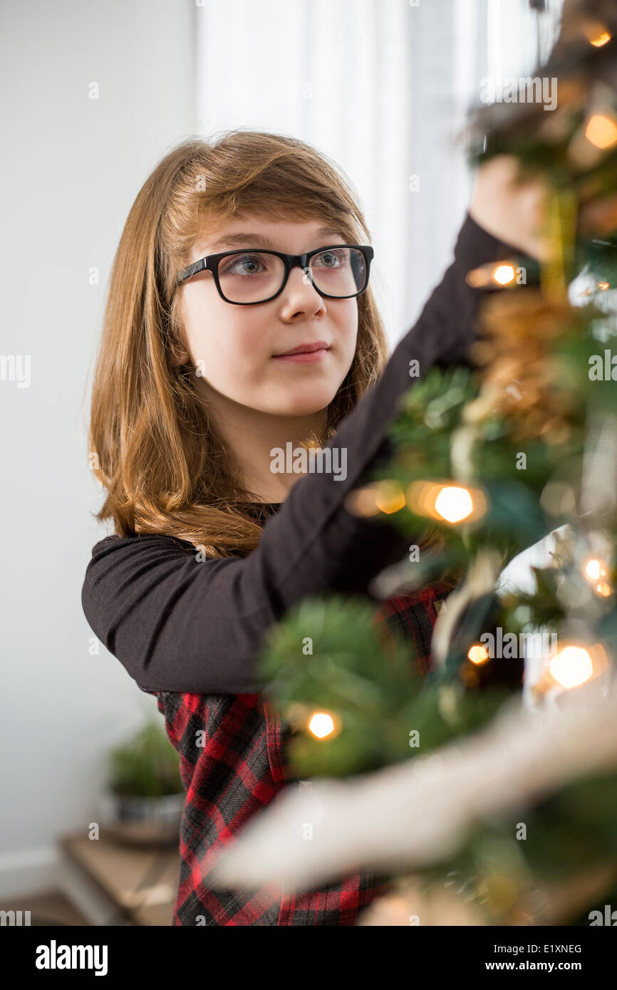 Teenager-Mädchen schmücken Weihnachtsbaum zu Hause Stockfoto