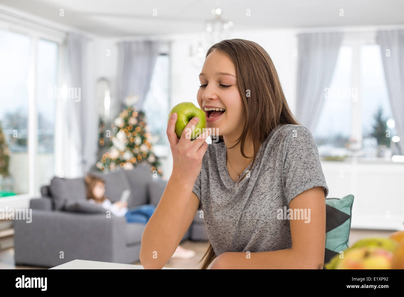 Glückliches Mädchen essen Apfel zu Hause Stockfoto