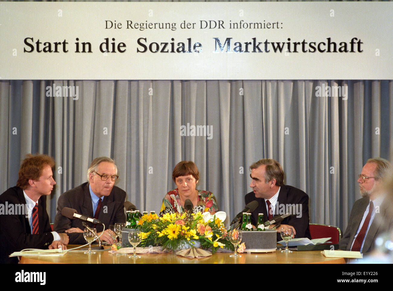 Bundesminister für Finanzen Theo Waigel (CSU, 2. von rechts) und DDR-Minister der Finanzierung von Walter Romberg (2. von links) zusammen mit repräsentativen DDR-Regierung-Sprecherin Angela Merkel (M) am Tag der Währungsumstellung in der DDR am 1. Juli 1990. Stockfoto