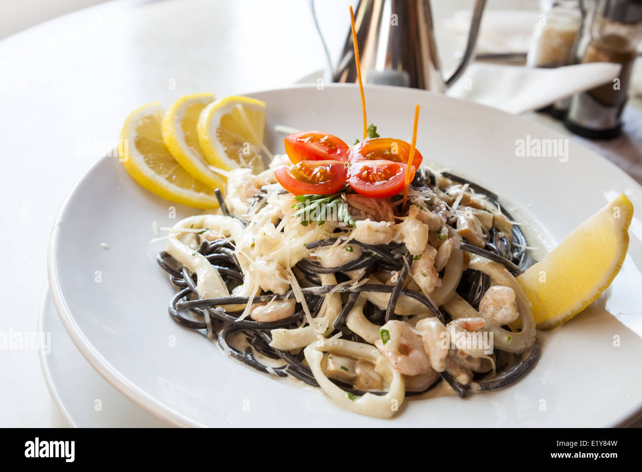 Schwarze Spaghetti mit Meeresfrüchten auf weißen Teller Stockfoto