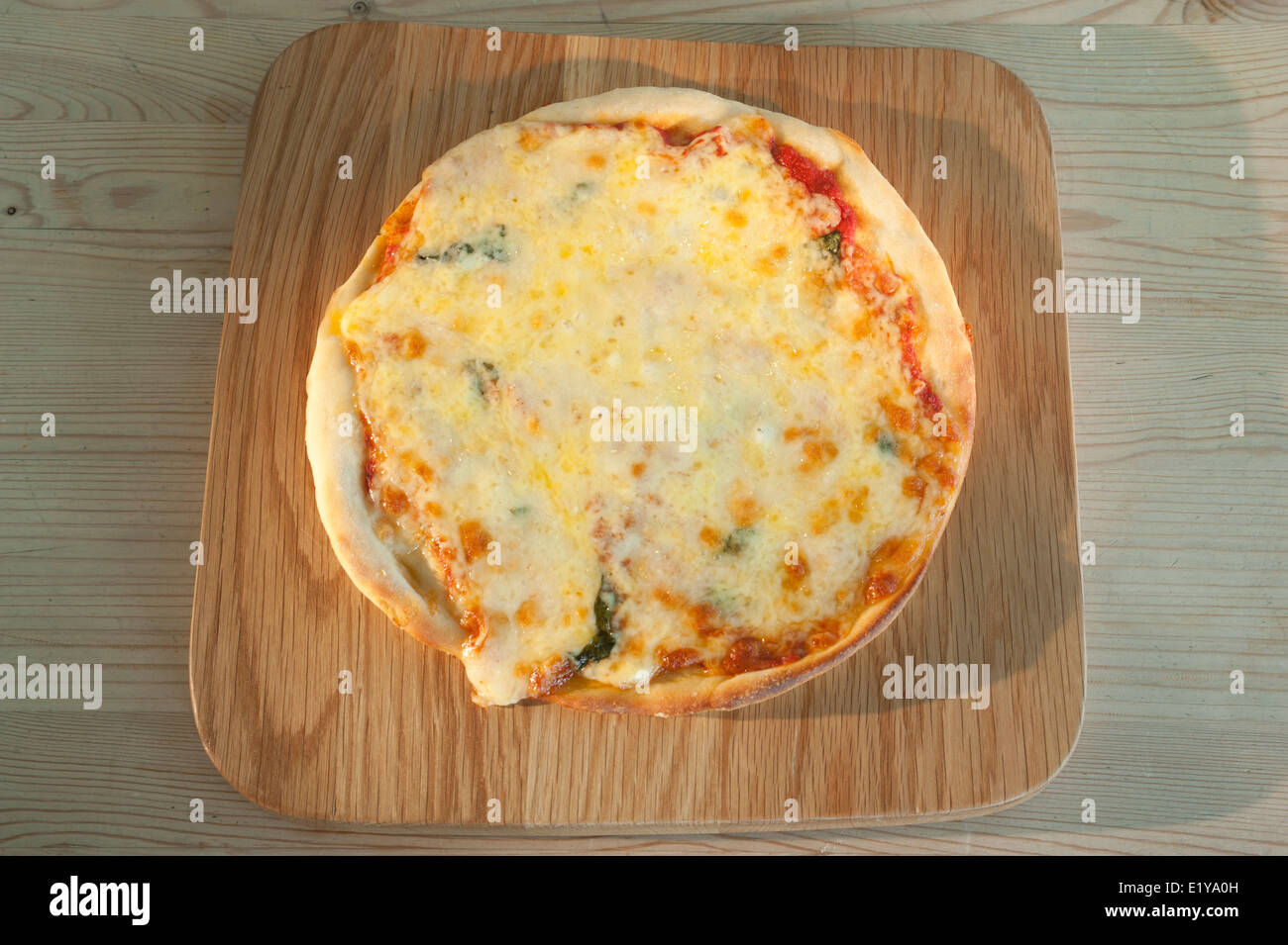 Tomate-Mozzarella und Basilikum Pizza auf einer Holzplatte. Stockfoto
