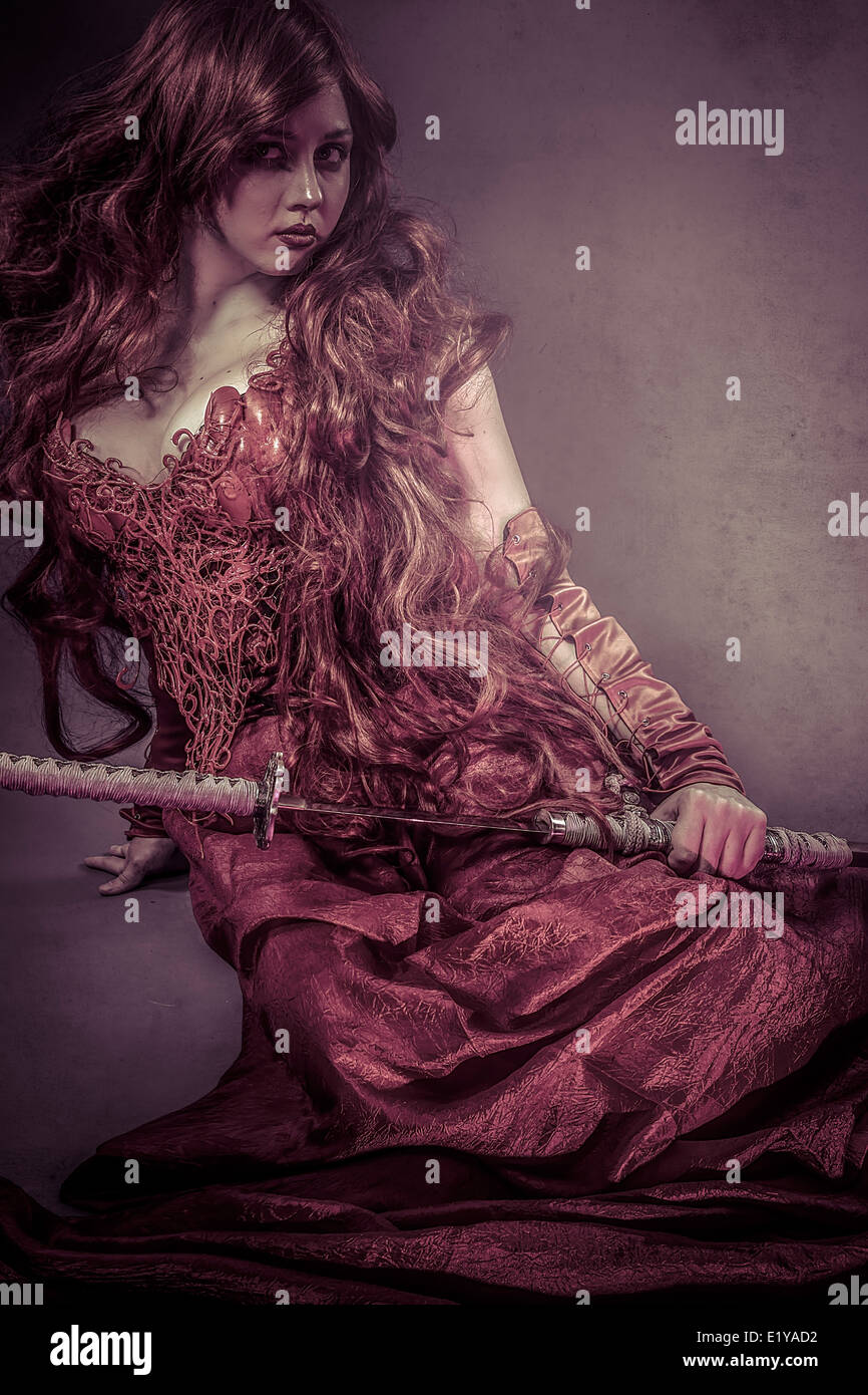 Rote Königin Katana, schöne Frau, gekleidet in roten Rüstung Drachenschuppen Stockfoto