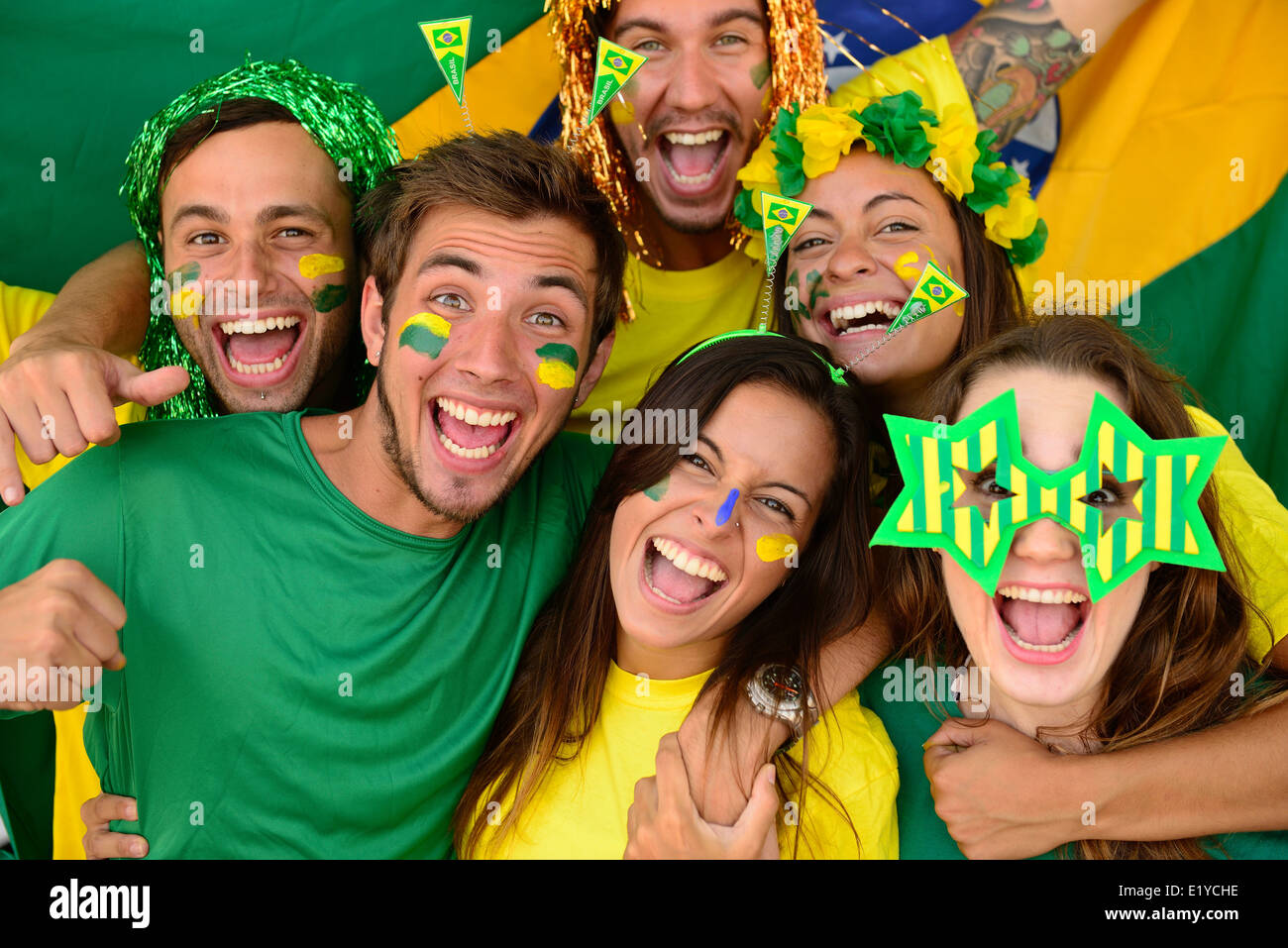 Glückliche Gruppe von brasilianischen Sport-Fußball-Fans begeistert feiert Sieg zusammen. Stockfoto