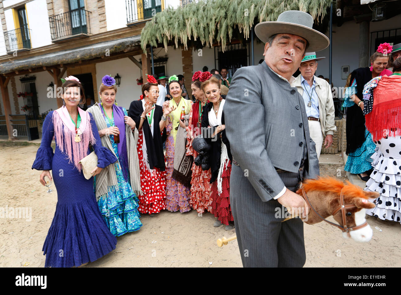 Rocio Romeria - Mann auf Steckenpferd Re-inszeniert Stierkampf mit anderen Männern während Frauen in traditionellen andalusischen Uhr auf Kostüm Stockfoto