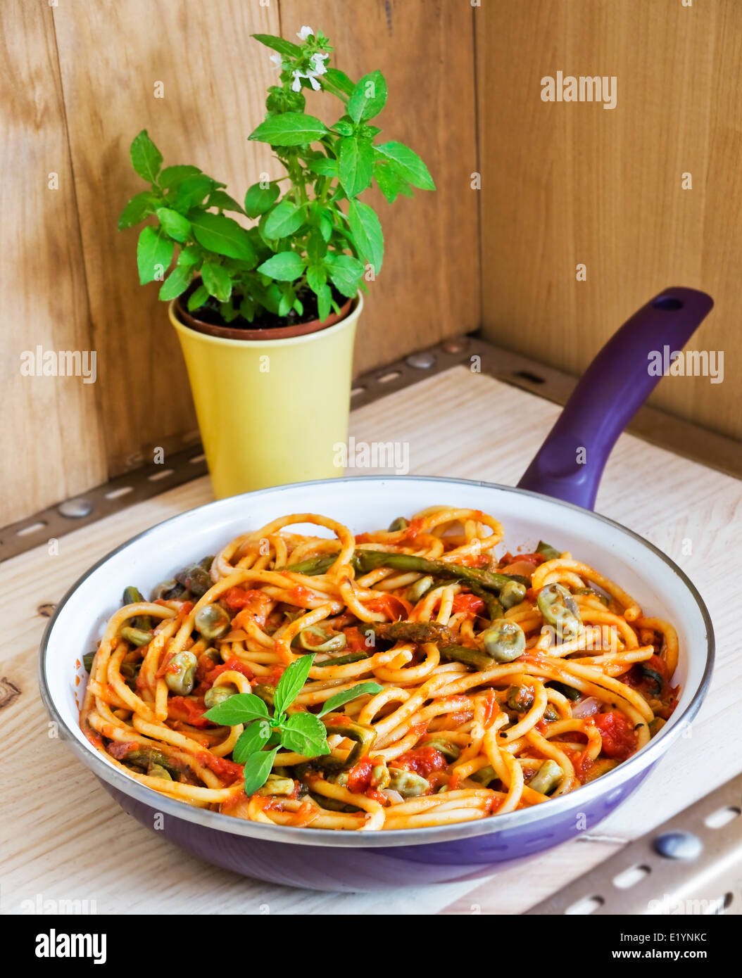 Bucatini Pomodoro (Tomatensauce) mit saisonalem Gemüse in einer Pfanne erhitzen. Vegetarische Pasta. Stockfoto