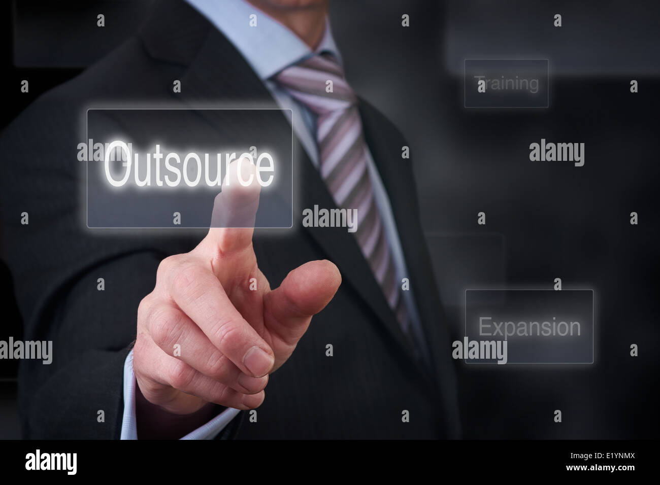 Ein Geschäftsmann deuten auf eine Business-Outsourcing-Taste auf einen klaren Bildschirm. Stockfoto