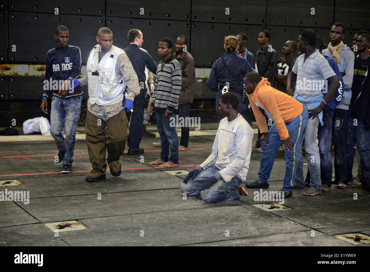 US Navy Matrosen übertragen Flüchtlinge gerettet Boote auf dem gut Deck der USS Bataan nach Erhalt einer Aufforderung zur Unterstützung von der italienischen marine Patrol 6. Juni 2014 im Mittelmeer sinken. Mehr als 300 Flüchtlinge aus Afrika wurden gerettet und an die Regierung von Malta überwiesen. Stockfoto