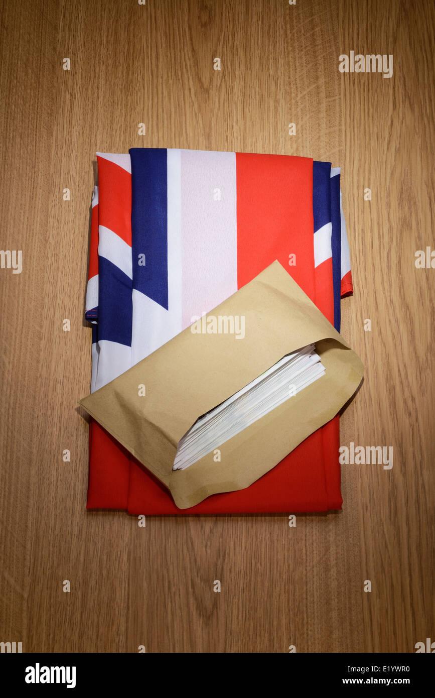 Großbritannien Union Jack-Flagge mit einem braunen Umschlag voller Geld Stockfoto