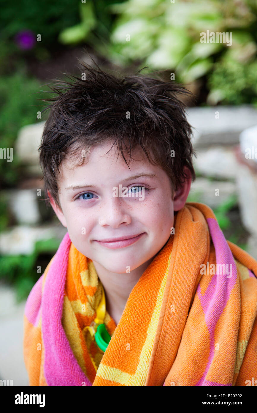 Junge nach dem Schwimmen im Pool mit nassen Haaren in Handtuch gewickelt. Stockfoto