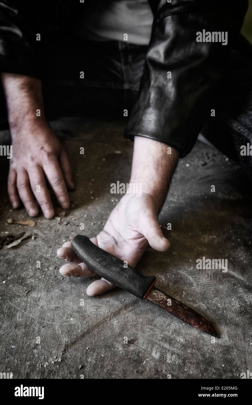 die Hände des Mannes mit einem alten, rostigen Messer Stockfoto