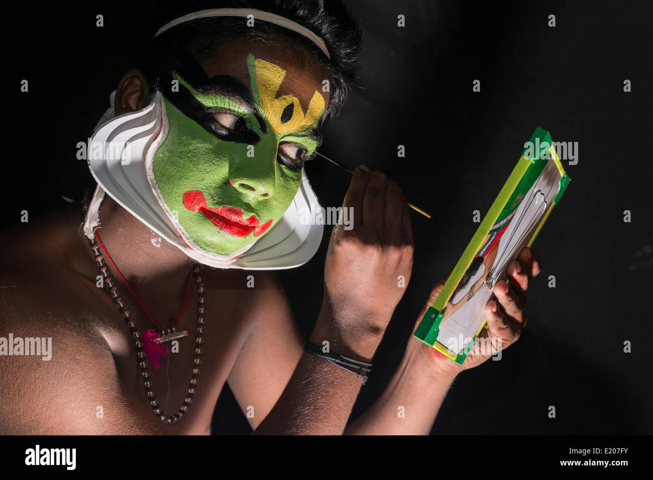 Ein Katakali Künstler wendet das Make-up des Zeichens Arjun für die Santhana Gopalam spielen bei einem Tempelfest, Ayroor Stockfoto