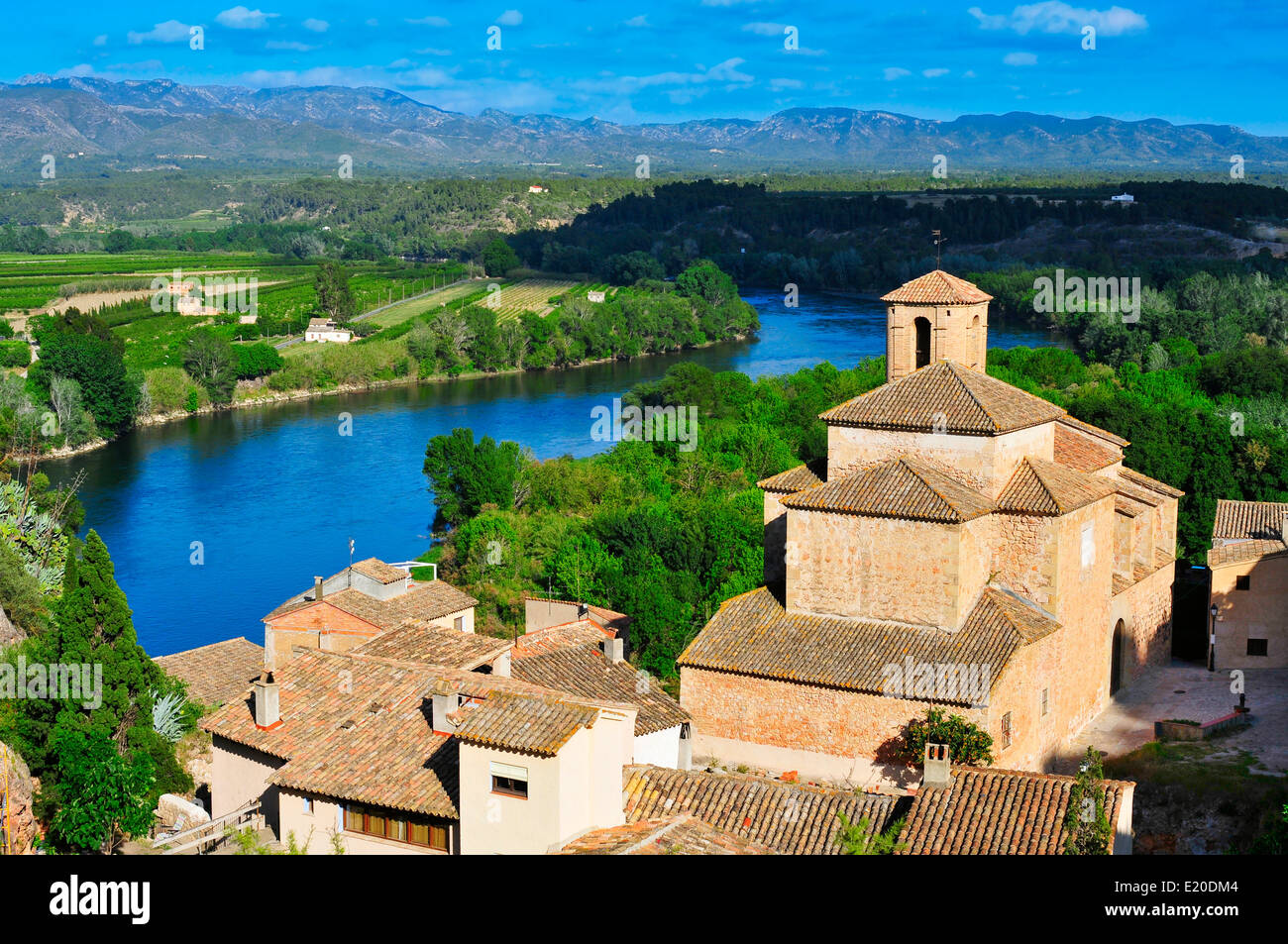 Blick auf die alte Stadt von Miravet, Spanien und Fluss Ebro mit der Bergkette Serra de Cardo im Hintergrund Stockfoto