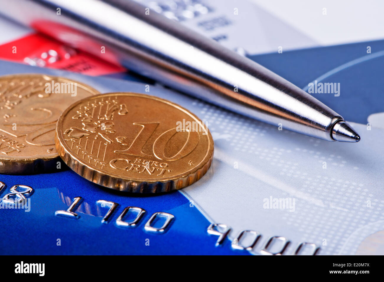 Kreditkarten und Münzen mit einem Kugelschreiber. Stockfoto