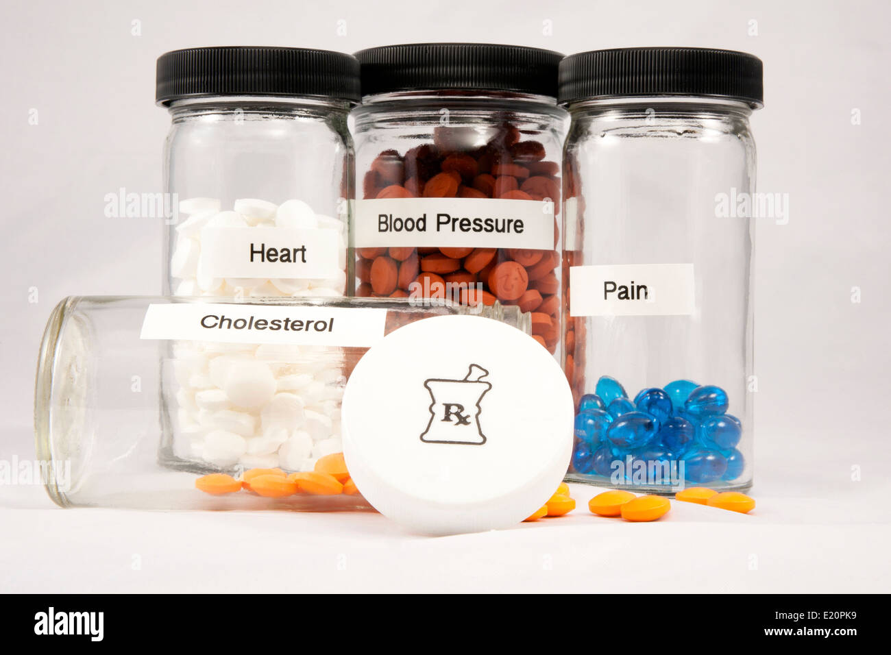 Klaren Flaschen gefüllt mit Pillen und Kapseln beschriftet, Cholesterin, Herz, Blutdruck und Schmerzen Stockfoto